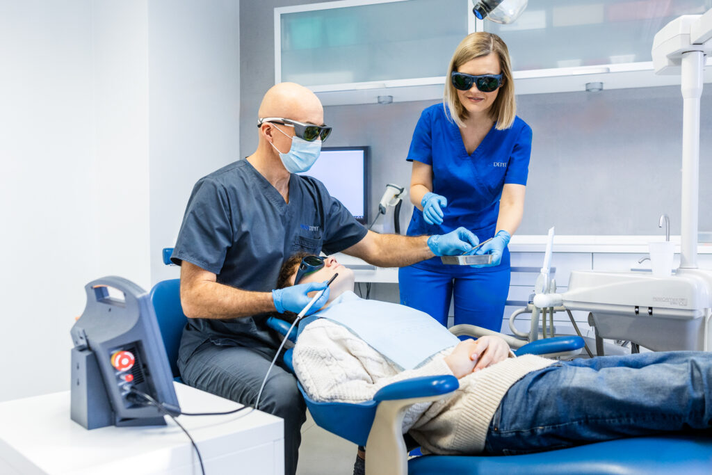 Zdjęcie przedstawia pacjenta podczas laserowego wybielania zębów w klinice stomatologicznej Periodent